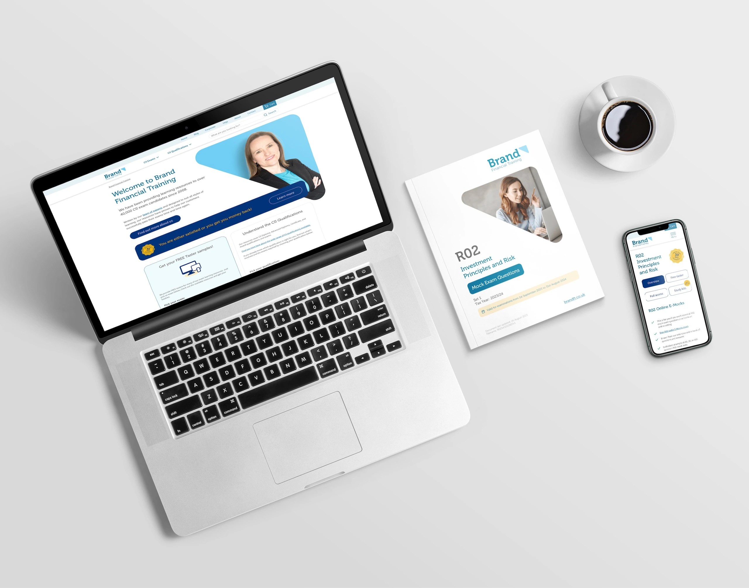 Desk with laptop and mobile phone showing mock up of new Brand FT website with a Brand FT learning documents designed by Gavin Stretch alongside cup of coffee.