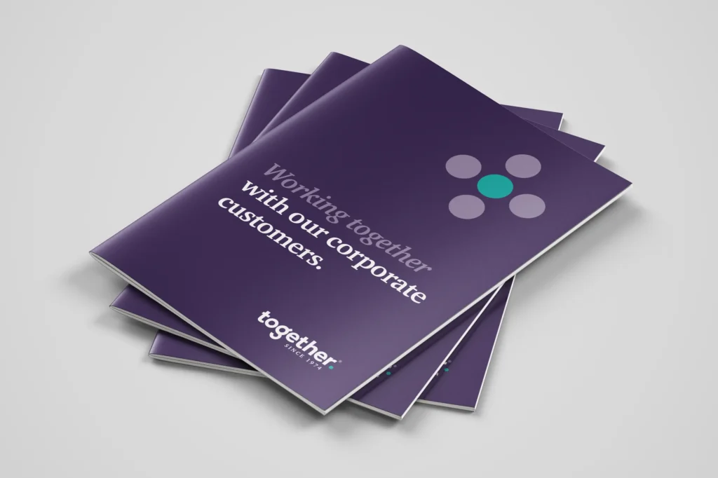 A pile of 3 corporate brochures designed by Gavin Stretch of Mode=Create for a financial lender. The brochure on the top of the pile reveals the front cover which is mainly aubergine and has the title 'Working together with our corporate customers.'